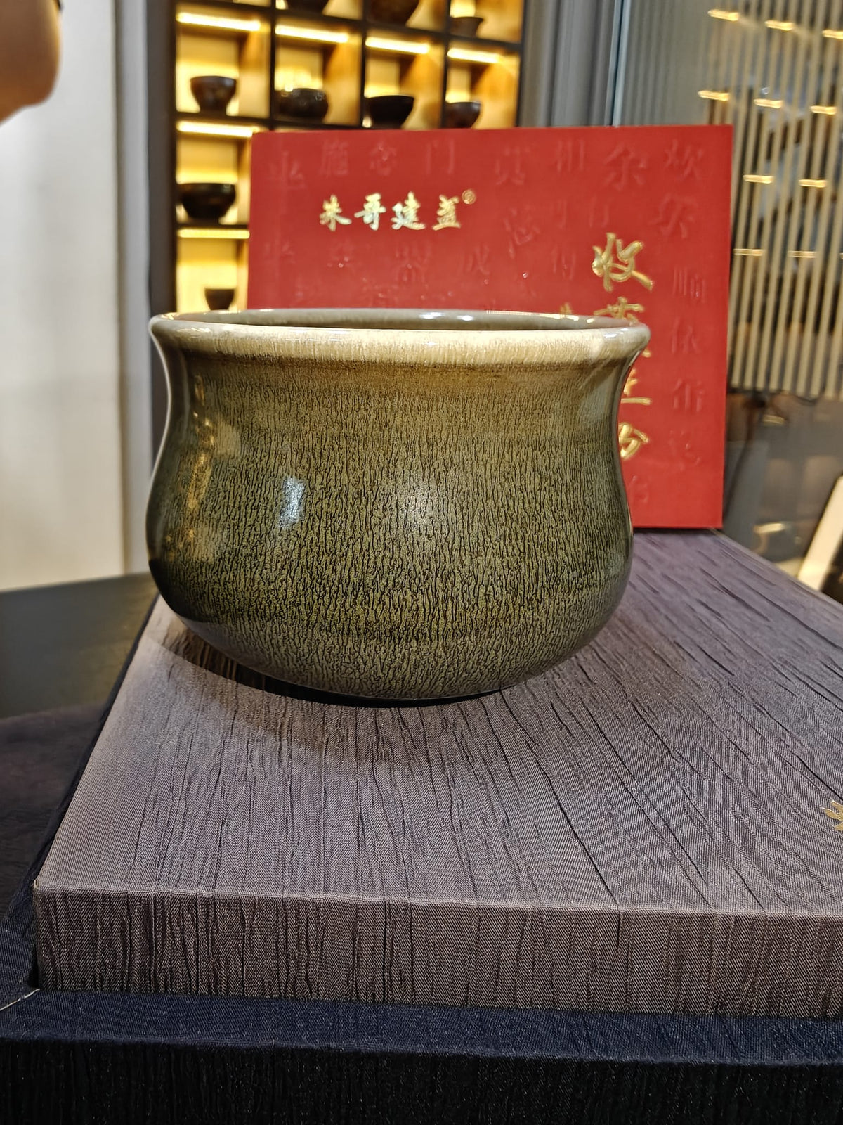 Olive green 佛度杯 JianZhan tea cup side profile showing hare's fur glaze