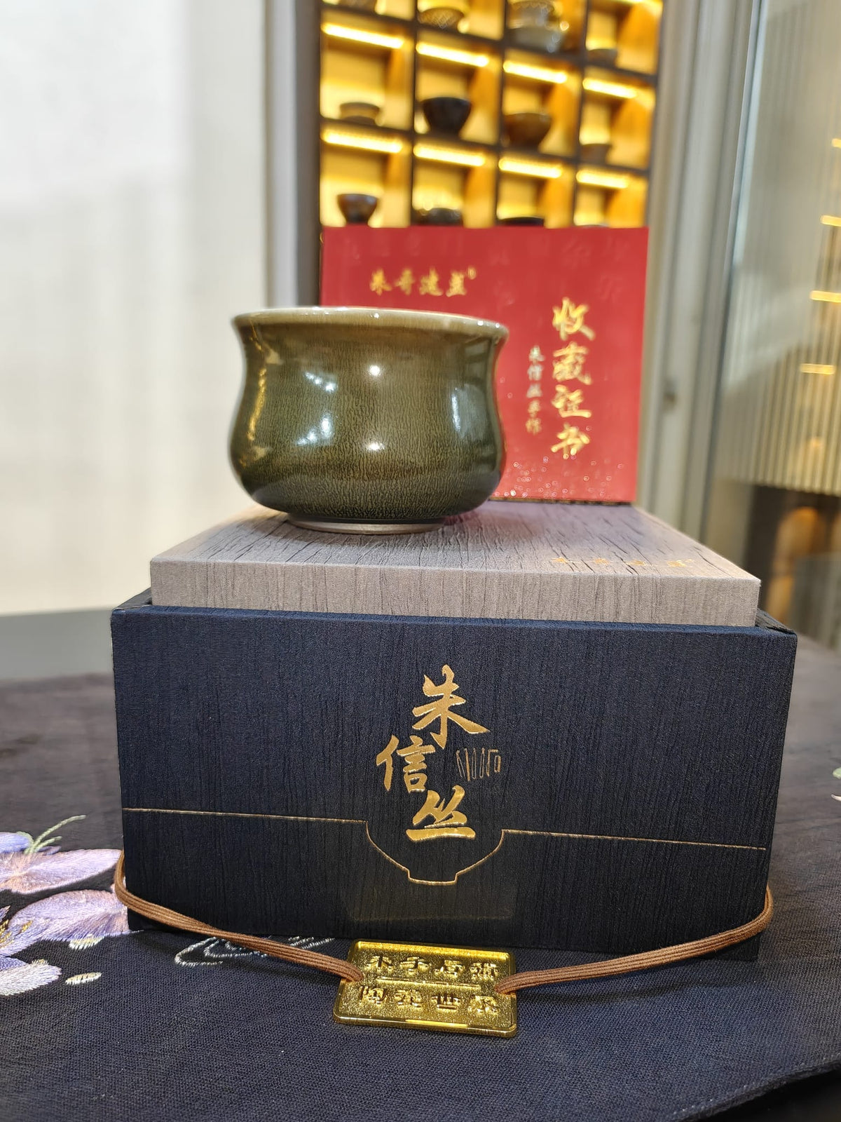 Olive green censer form JianZhan tea cup by 朱信丛 with navy gift box and collector's certificate