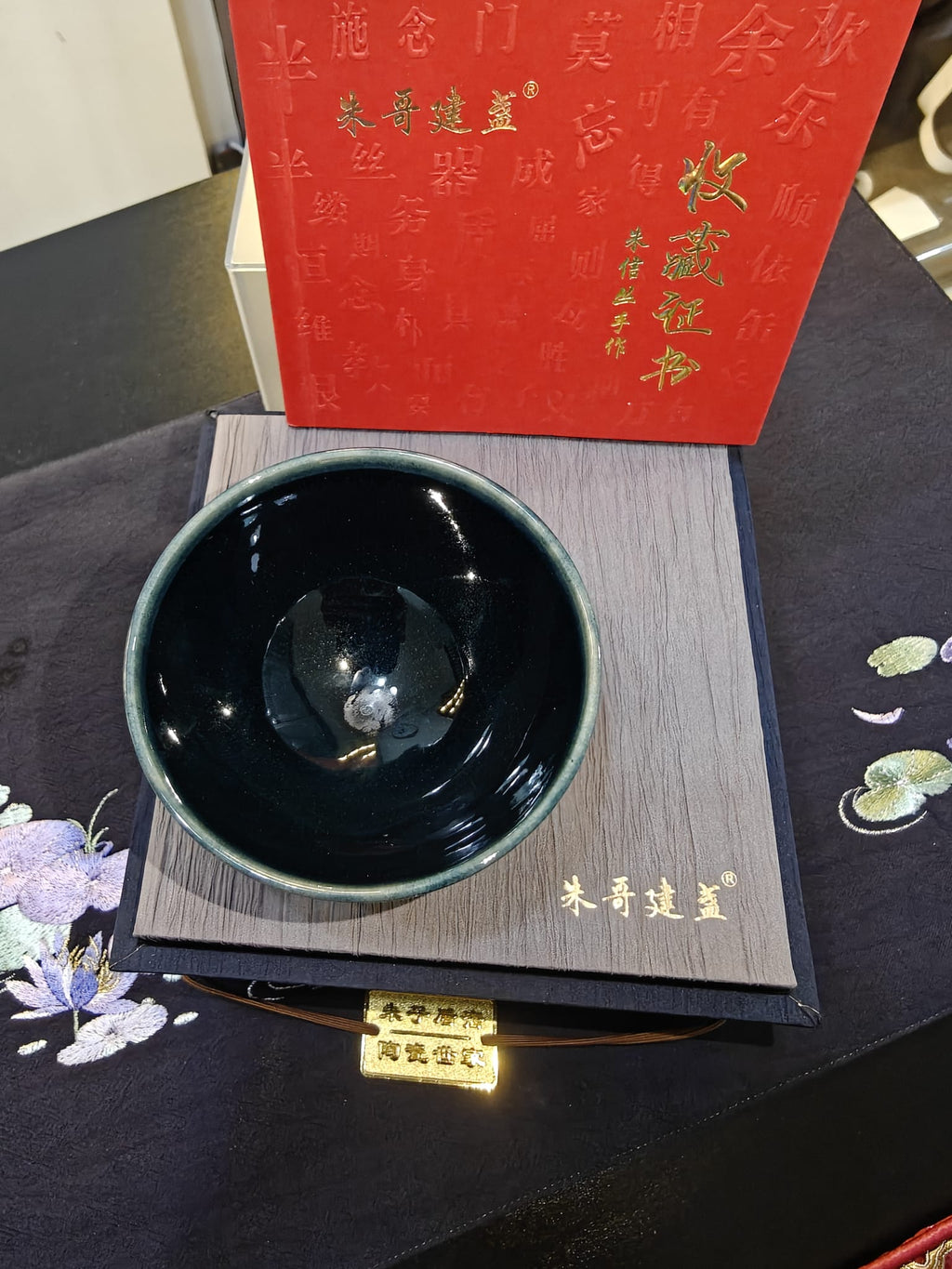 Deep teal-black mirror glaze JianZhan tea bowl interior angle showing teal rim shift