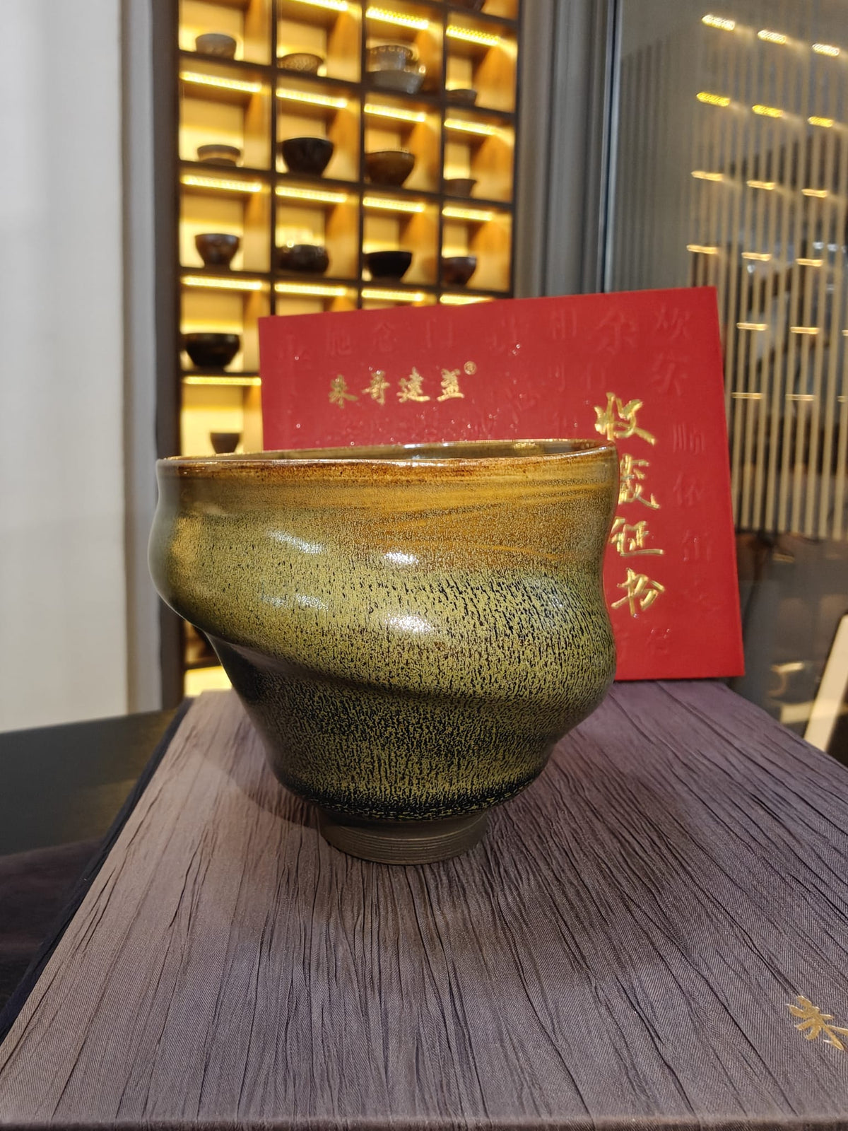 Olive-gold conch shell JianZhan tea bowl exterior — twisted asymmetric form with hare's fur glaze