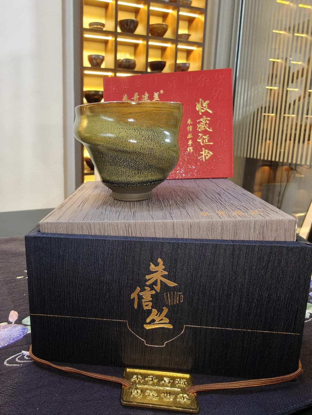 Olive-gold conch shell form JianZhan tea bowl by 朱信丝 with navy gift box and collector's certificate